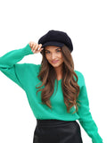 Smiling woman portrait wearing navy blue wool paperboy hat white background