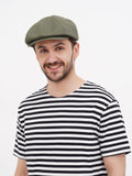 Front view olive linen newsboy cap showing soft straight visor and 8-panel crown