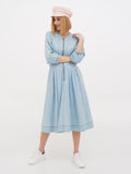 Woman in peach linen Breton cap and light blue dress full length side angle
