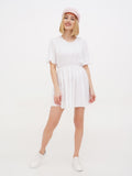 Woman wearing pink linen Breton cap and white dress, full length front