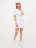 Woman standing in pink linen Breton cap and white summer dress