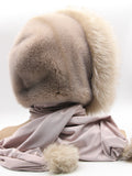 Three-quarter back view powder pink mink hood scarf wrap with fox pompon at scarf end visible