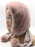 Powder pink dyed mink fur hood scarf with matching mink pompons on mannequin, side view