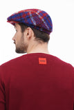Full body standing man in red blue plaid flat cap burgundy sweater black jeans casual