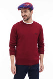 Three quarter view man wearing red blue plaid flat cap with burgundy knit sweater