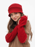 Side view of woman wearing red wool cloche hat with camel knit sweater