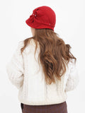 Full-length view of red cloche hat with cream sweater and jeans