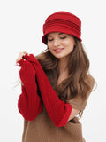 Woman in red cloche hat holding red gloves, close-up front view
