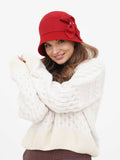 Side profile of red wool cloche hat showing fabric bow detail