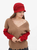 Woman in red cloche hat and camel sweater, standing, full-length view