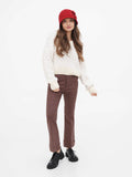 Woman in red cloche hat, three-quarter view, cream knit