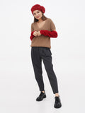 Red French wool beret hat on woman in brown knit sweater and dark trousers, full length front view