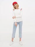 Woman in red Breton cap, striped sweater and jeans standing full length