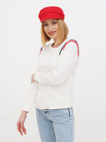 Side angle of woman in red linen Breton cap with striped top and jeans