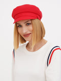 Woman wearing red linen Breton cap with striped sweater, smiling