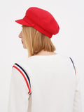 Side back view of red linen newsboy cap showing rounded crown and peak