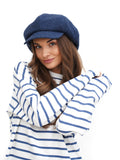 Woman in blue and white striped marinière top wearing royal blue wool newsboy cap portrait