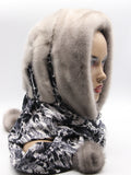 Sapphire mink fur hat hood with blue watercolor leopard print scarf and pompons on female model, front view