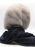 Three-quarter back view sapphire mink fur hood with dark patterned fabric scarf hanging loose