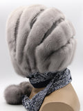 Side profile sapphire mink suede striped fur hat hood on mannequin showing stripe depth and pompon at tie end