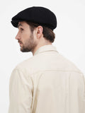 Side close-up black cashmere newsboy cap showing wool texture and slouchy fit