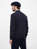 Three quarter view man wearing navy newsboy cap with dark jacket casual outfit