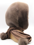 Detail view tobacco brown mink pompon at end of coordinated fabric scarf showing compact mink pompon finish
