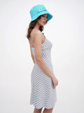 Back view of woman in turquoise bucket hat and striped dress