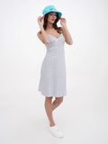Woman in turquoise bucket hat adjusting brim, striped dress, side view