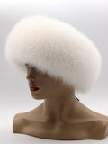 White arctic fox hat tilted to the left, soft fur covering the tops of the ears