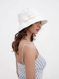 Woman wearing white cotton bucket cloche hat with striped summer dress