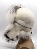 White fur hat in profile with mink ear flaps folded up and tied over the crown