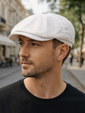 Man in white linen baker boy cap three quarter view city black tshirt