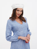 Close-up of white linen beret on woman's head showing structured crown and clean white tone