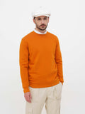 Full length man white linen cap orange sweater beige pants