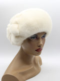 White mink beret with large mink flower three-quarter left view showing flower position and white fur dome