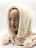 Three-quarter view white mink fur hat hood showing cool white mink surface and light beige scarf with pompons