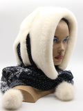 White natural mink fur hat hood with dark floral scarf and white pompons on female model, front view
