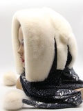 Side profile white mink fur hat hood scarf on mannequin showing white pompon and dark floral fabric