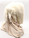 Detail view light beige fabric scarf of white mink fur hat hood showing three white mink pompons at different positions