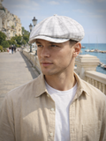 Man wearing white plaid linen newsboy cap front view summer coastal
