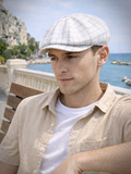 Man in white plaid linen newsboy cap three quarter view summer sea