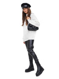 Woman wearing black Breton cap with leather trousers and white sweater full body