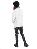 Woman wearing black cashmere Breton cap with oversized white sweater