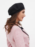 Women's black linen beret side profile showing beret angle on head and linen fabric surface