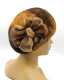 Women's golden brown mink fur beret with handcrafted mink flower, side profile view showing honey-brown fur color and multi-petal flower detail