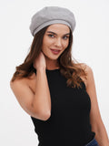 Women's grey linen beret hat close-up side view showing flat crown structure and light grey linen texture