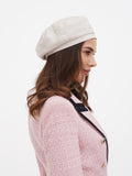 Women's ivory linen beret worn tilted to the side, side profile view showing flat crown structure
