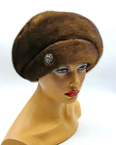 Women's pastel brown mink fur beret voluminous crown three-quarter view showing soft caramel-brown fur and full dome silhouette
