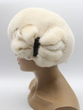 Women's pearl beige mink fur beret with handcrafted mink bow side profile view showing cream-ivory fur and structured bow detail